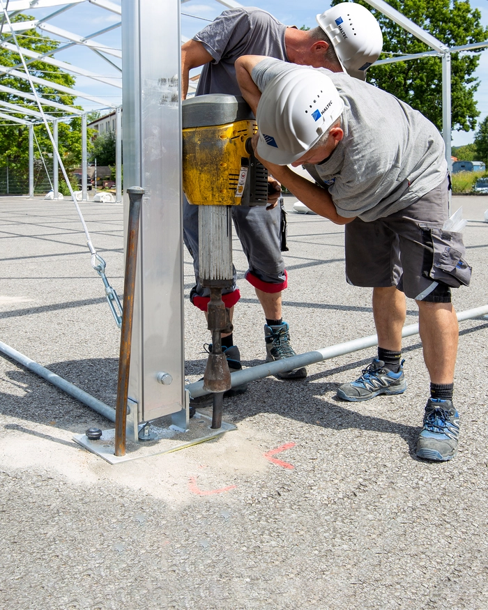 Driving in ground pegs on temporary building